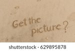 Small photo of Handwriting words "Get the picture?" on sand of beach.