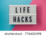 life hacks - text on a display on blue and pink bright background.