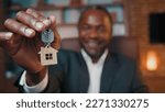 Small photo of Close-up mature african american man hold keys new home blurred male real estate agent demonstrate key sell property give affordable housing make special offer happy ethnic homeowner winning apartment