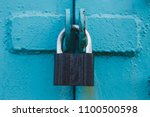 Golden padlock on old blue wooden door