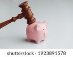 Small photo of Judge wooden gavel is brought over piggy bank. Bank account arrest concept