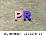 Small photo of Color alphabet letter in word PR (Abbreviation of purchase requisition or public relations) on wood background