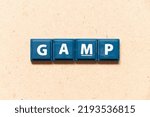 Small photo of Tile letter in english word GAMP (Abbreviation of Good Automated Manufacturing Practice) on wood background
