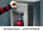 Small photo of Hand of a traveler pressed the button of drinking water filling station at the Airport, Refill, Reusable bottle. Eco friendly, Environmental awareness, Clean water, Zero waste, Plastic free july.