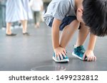 Small photo of A little hyperactive child bend down his body fidgeting in the walkway. Behavioural disorders, Autism, Attention deficit, Oppositional defiant, Disruptive behaviour, Disobedient child, Parenting.