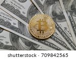 A symbolic coins of bitcoin on banknotes of one hundred dollars. Exchange bitcoin cash for a dollar.  