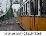 Small photo of Tramcar sideview passing through a green bridge
