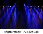 Performance moving lighting on construction light beam ray downward in yellow blue color, on Concert and Fashion Show stage ramp