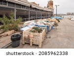 Small photo of Acre, Israel, December 04, 2021 : Containers of fishing tackle and fishing boats on the embankment at the port in Acre old city, in northern Israel