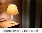 Lamp. Night light by the bedside table with warm light. Intimate setting. Lamp for reading a book on the bed. Bedside table with night light