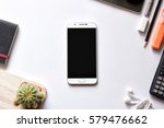 Modern white office work table with smartphone mock up notebook pen and calculator top view 