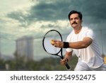 Small photo of Male tennis player ready to serve at tennis court.