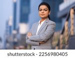 Small photo of Young woman in business wear standing with armes crossed in business environment