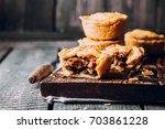 Fresh Traditional Australian meat mini pie on the wooden board on table background, closeup with copy space, rustic style. Delicious food