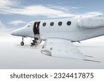 Small photo of Close-up of the modern white private jet with an opened gangway door isolated on bright background with sky
