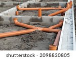 New Installed pipework system. Sewer Line developed and mounted on the construction site. New Orange PVC plastic Drainage pipe Tube