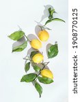 Small photo of Ripe fresh Sicilian lemons with green leaves on white background. Organic citrus fruits with bright sunlight. Healthy food concept