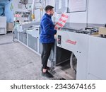 Small photo of Istanbul Turkey- July 11, 2023: people working in a sticker printing factory. worker uses a stickier printing machine. sticker printer.