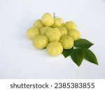 Small photo of Many gooseberries and gooseberry leaves are placed on a white background. It has a sour taste. It is a gooseberry that I naturally planted.