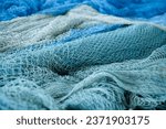 Small photo of pile of blue fishing net with white floats. Trawler fishing net and floats. Fishing nets and ropes. tool for catching fish