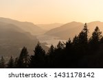 Layers of mountains and silhouetted trees in the Columbia River Gorge during golden hour sunset
