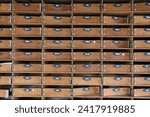 Small photo of Multiple pigeonhole type letterboxes with numbered plates