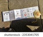 Small photo of Santiago de Compostela - August 14, 2023: Credential of St. James Pathway (Camino de Santiago), stamped by stores, churches, and waypoints along the way. A shell, symbol of pilgrims and a partial boot