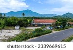 Small photo of Mountain and tress between have single house on road side.