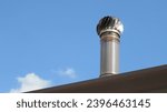 Small photo of Spinning chimney cowl on top of a house.