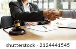 Small photo of Lawyer and client shake hands, after winning a lawsuit where a lawyer hired by a client in a fraud case and proceeding in a fair and correct manner, the client wins the case. Fraud litigation concept.