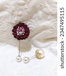 Small photo of flower brooch and pearl brooch in white
