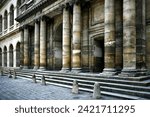Small photo of Paris ancient stone building colonnade with massive columns, arches and stucco fretwork. Stone steps and cobblestone pavement