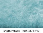 Small photo of turquoise sheepskin texture with soft hairs, natural fur for the designer, the concept of processing, production of furrier products, stress relief, psychological stress
