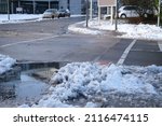 Small photo of part of street in city, pavement after heavy snowfall, wet snow melts, puddles, slush and mud impede movement of pedestrians and vehicles, concept traffic safety, work of public utilities