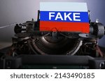 Small photo of fake news typed on old typewriter, national flags of Russia, retro style, concept of works of dishonest journalism, Fake concepts, staging to discredit information, retro technologies, news