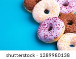 Assorted delicious donuts on bright blue background. Unhealthy, but delicious sweets. Copy space