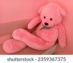 Small photo of Sweetness personified: A big pink teddy bear takes a relaxed seat on a matching pink chair, exuding sheer cuteness in every plush detail.