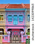 Small photo of Singapore - May 14 2019: Front view of traditional Singapore Peranakan or Straits Chinese shophouse with blue shutters and pink exterior in historic Joo Chiat East Coast