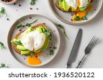 Healthy breakfast. Whole wheat toasted bread with avocado, poached egg, soft cheese and sprouts on white background. top view. Healthy diet food