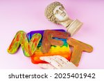NFT Non-Fungible token. Concept for blockchain system. Classical statue and Pop it toy on a pink background. Crypto art concept with an artificial hand