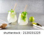 Two glasses of mojito and bar accessories. Mojito cocktail on a gray background. Cocktail with lime and mint