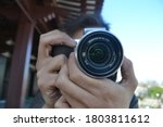 Closeup of man focusing camera lens. Photographer hands are on the lens and button ready to take a picture.