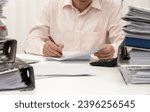 Small photo of A very busy bookkeeper in the office with pending reports
