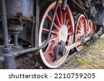 Small photo of Drive transmission mechanism in a historic and damaged steam locomotive standing on a sidetrack. Rail.