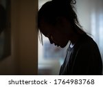 Small photo of Sad distraught woman in her room at home.