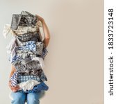Small photo of Surprised woman holding metal laundry basket with messy clothes on white background. Laundry. Isolated housewife. Copy space. Textile. Dirty wardrobe. Decluttering concept. Disorganized wife.