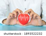 Good Healthcare and Insurance concept.Woman hand holding red heart with heart rate on blue background.Love and Family.