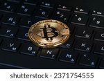 bitcoin metallic coin over black computer letters keyboard, closeup shot