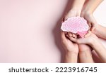 Small photo of hands holding human brain shape paper cut, idea creative intelligence thinking or Awareness of Alzheimer, Parkinson's disease, dementia, stroke, seizure or mental health. Neurology and Psychology care