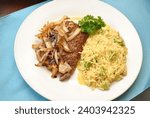 Small photo of Rice Served with Cube Steaks Smothered with Fried Onions